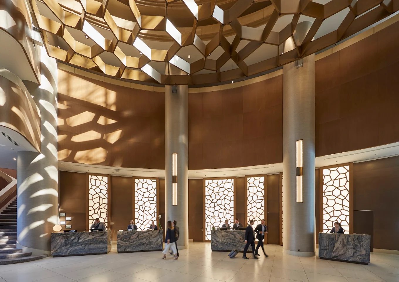Mandarin Oriental, Santiago — Reception with stone desks and the honeycomb ceiling above the curved check-in lobby.